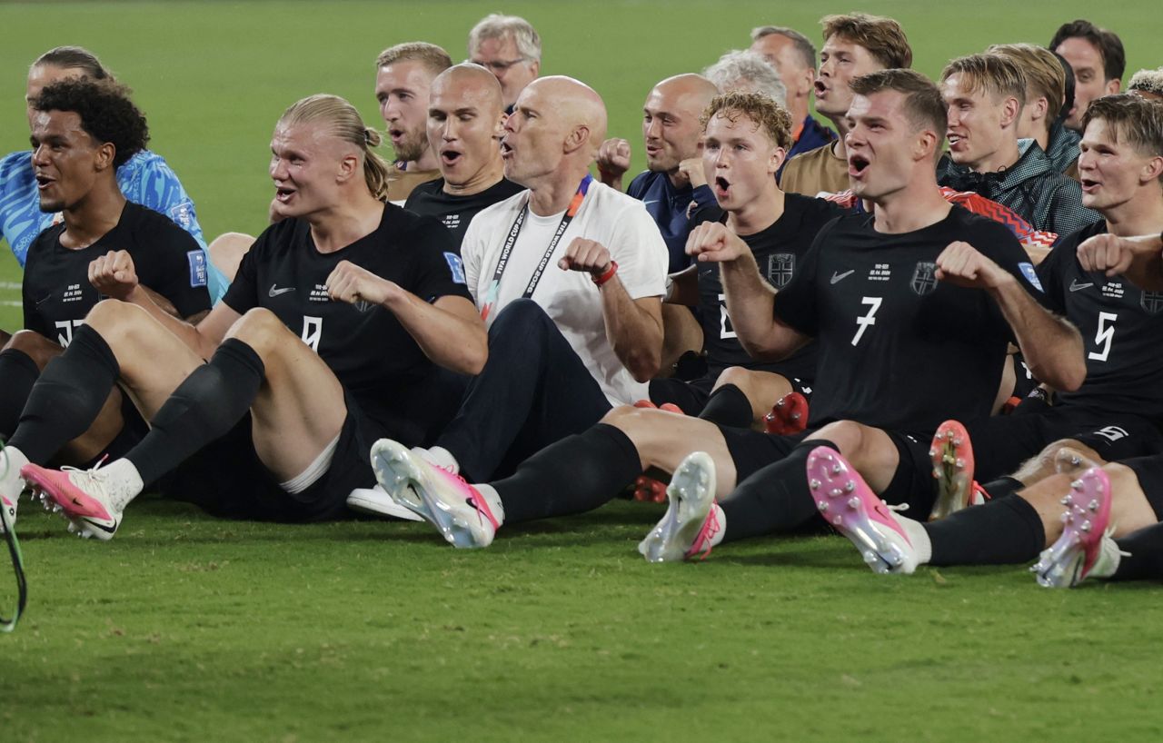 Jogadores da Noruega fazendo remada viking no gramado