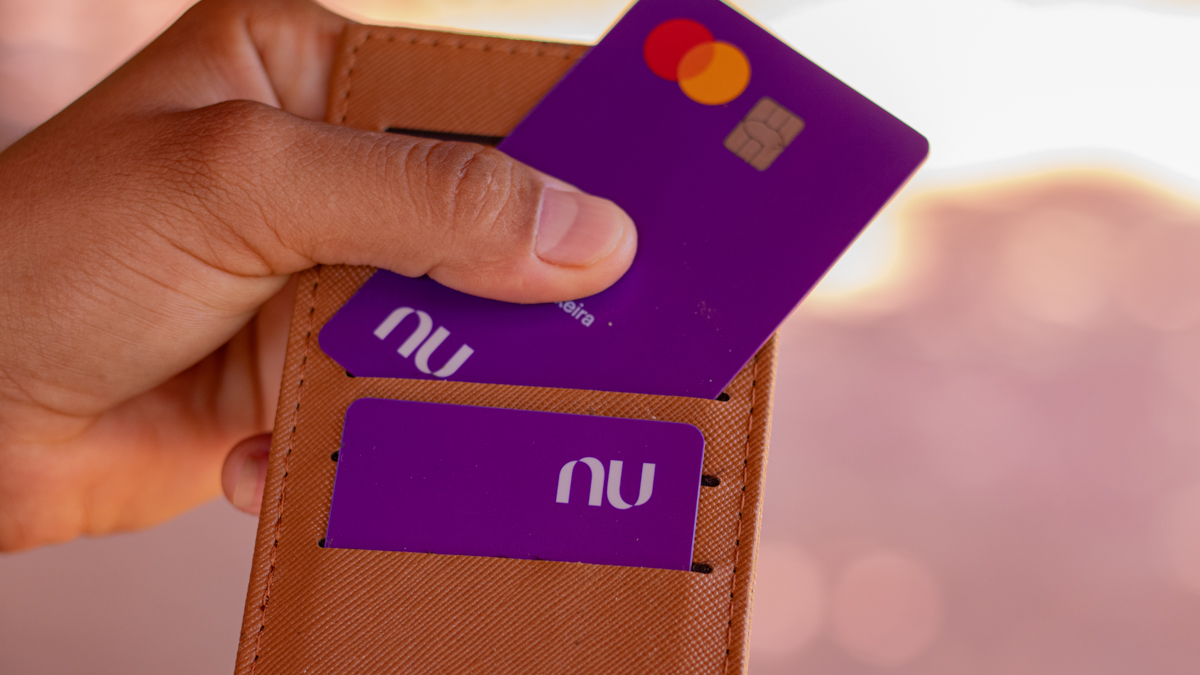 Cartão Nubank ao lado de representação de dinheiro e cadeado