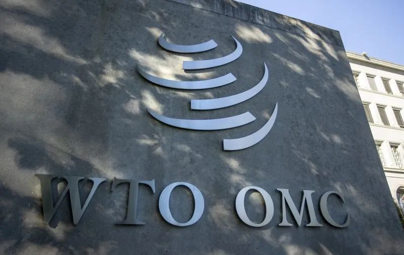 Bandeiras da OMC em frente a prédio institucional