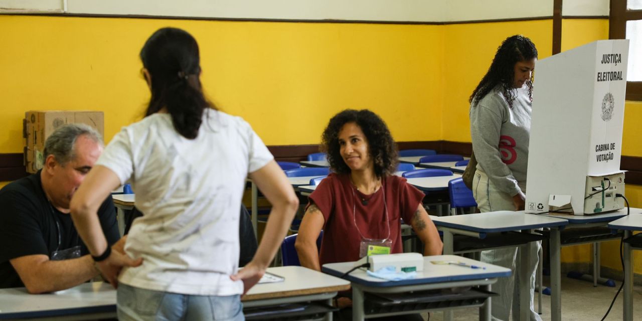 Eleitores na fila e urna eletrônica