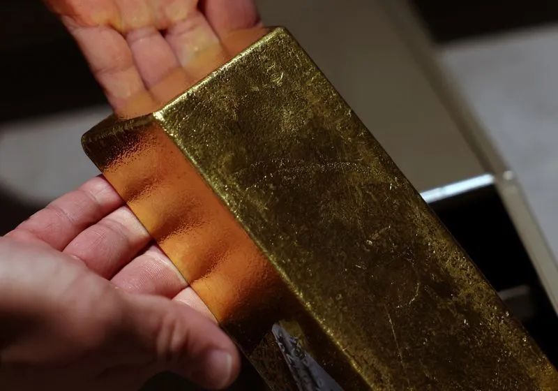 Barras de ouro sobre gráfico de mercado