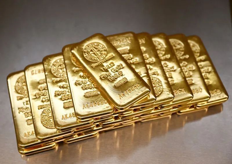 Barras de ouro com gráfico financeiro ao fundo