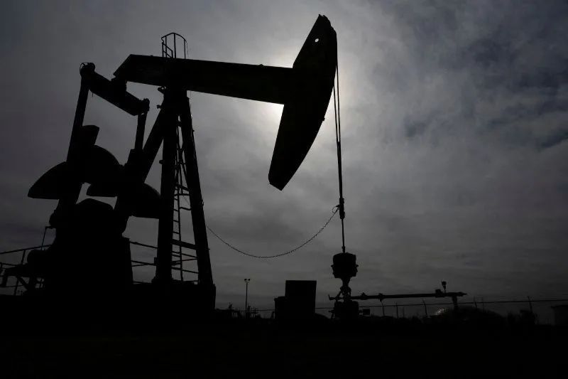 Barris de petróleo ao lado de bomba de combustível