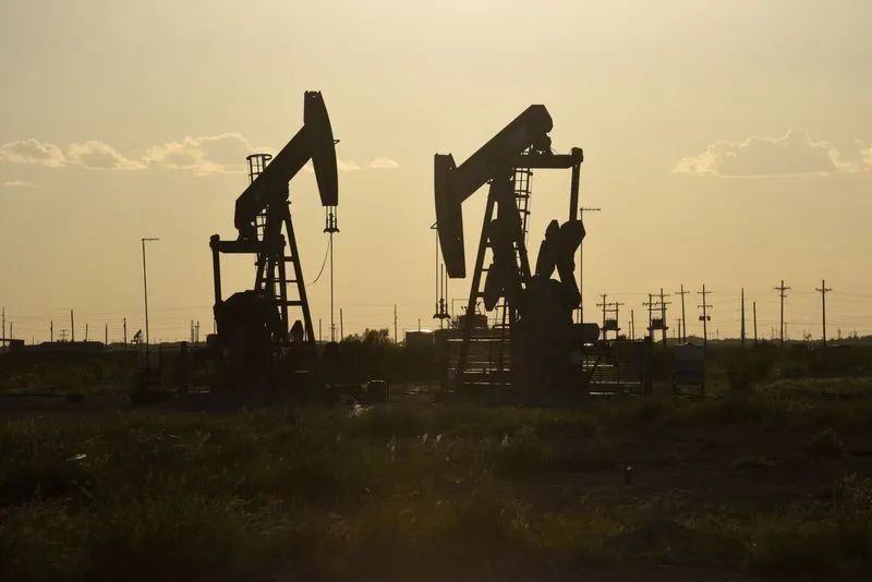 Tanques e plataforma de petróleo ao entardecer