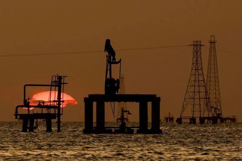 Plataformas de petróleo no mar ao pôr do sol