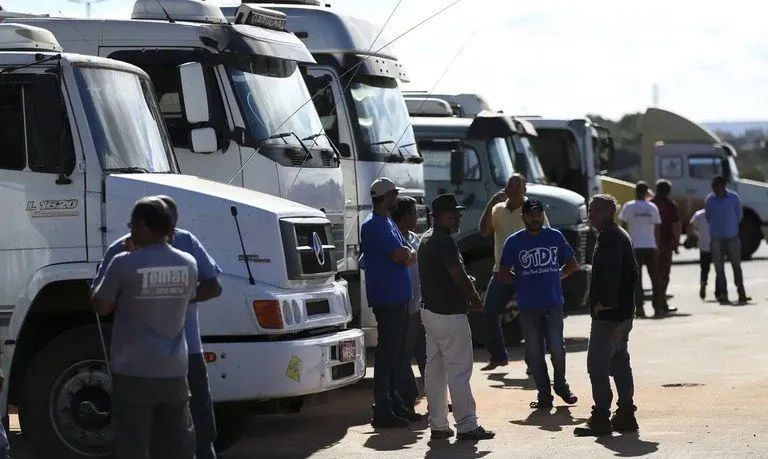 Caminhões em rodovia representando setor de transporte e logística