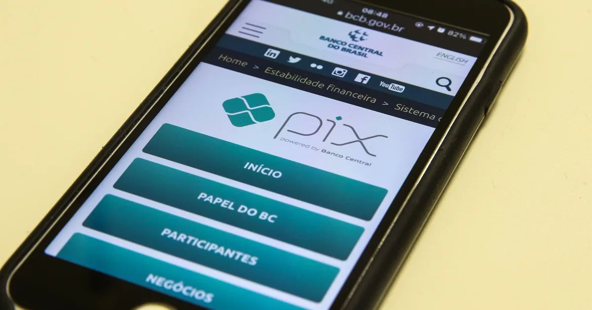 mãos segurando smartphone com aplicativo bancário aberto