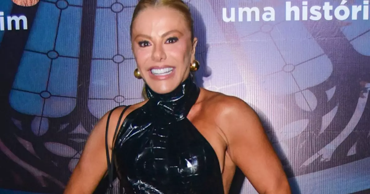 Poliana Rocha com vestido preto e fenda durante show de Leonardo