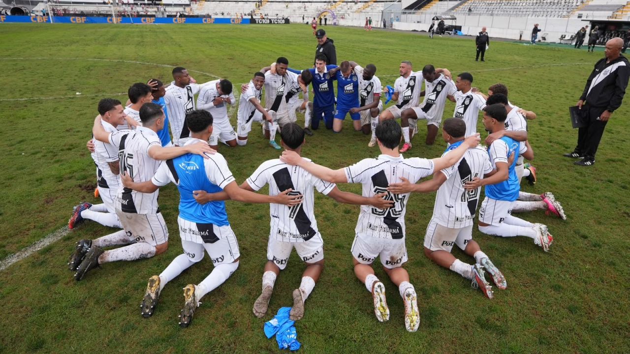 Jogadores da Ponte Preta ajoelhados celebram vitória sobre o CRB