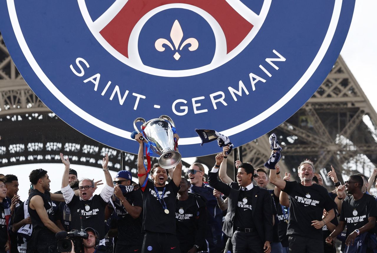 Jogadores do PSG comemorando em frente à Torre Eiffel