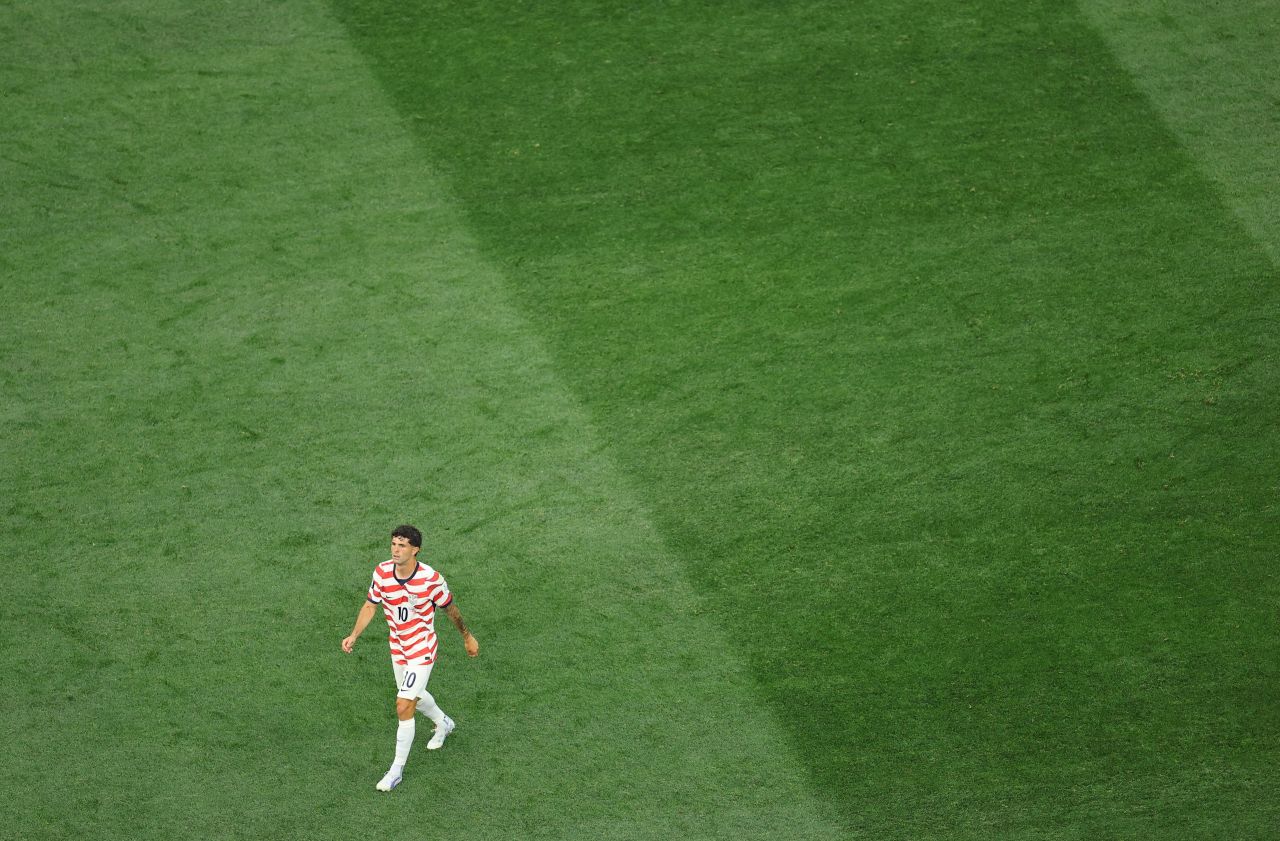 Christian Pulisic sentindo a panturrilha enquanto deixa o gramado