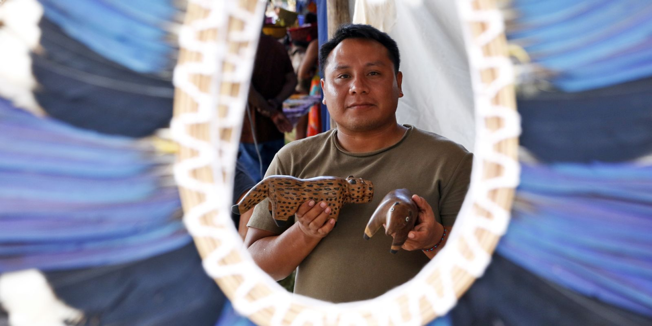 Artesão indígena com cocar de penas