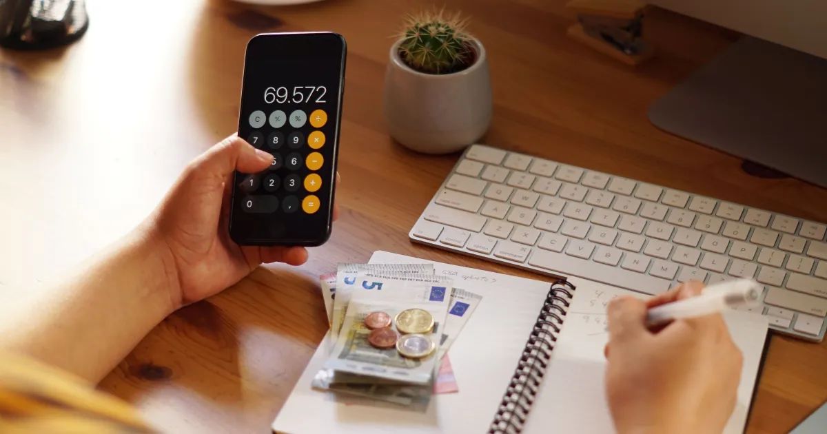 Pessoa organizando finanças com calculadora e planilha