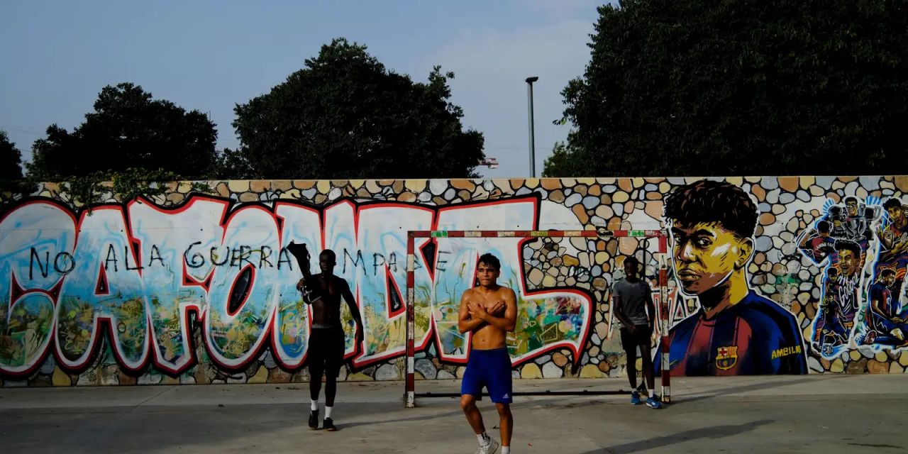 Crianças brincam no campo de Rocafonda diante de mural de Lamine Yamal