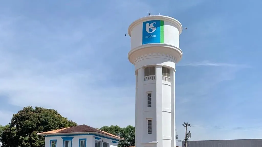 Logo da Sabesp com tubulação de água ao fundo