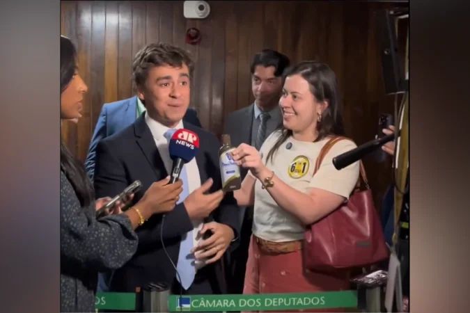 Deputada Sâmia Bomfim entregando frasco de óleo de peroba a Nikolas Ferreira no Congresso