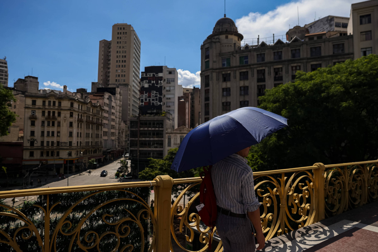 Céu com nuvens e sol sobre prédios de São Paulo