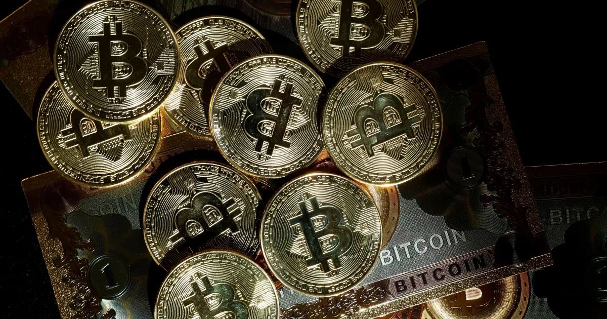 Logotipo da Strategy ao lado de gráfico com queda do preço do bitcoin