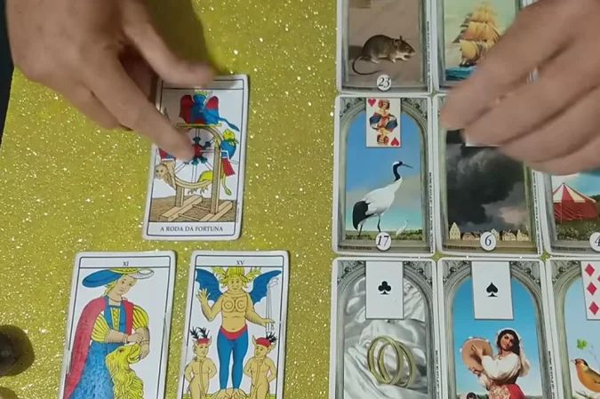 Baralho cigano e cartas de tarô sobre mesa de madeira
