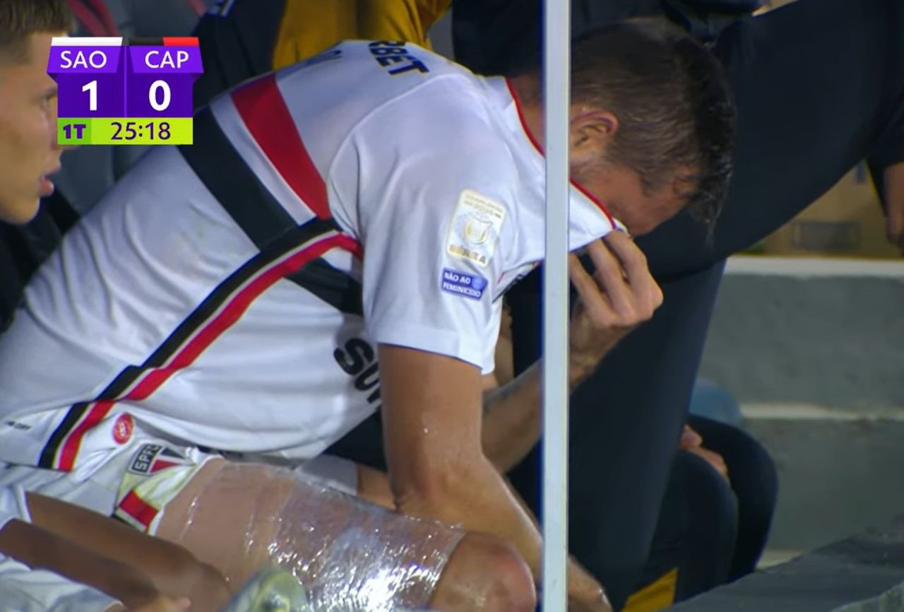Rafael Tolói no banco com gelo na coxa
