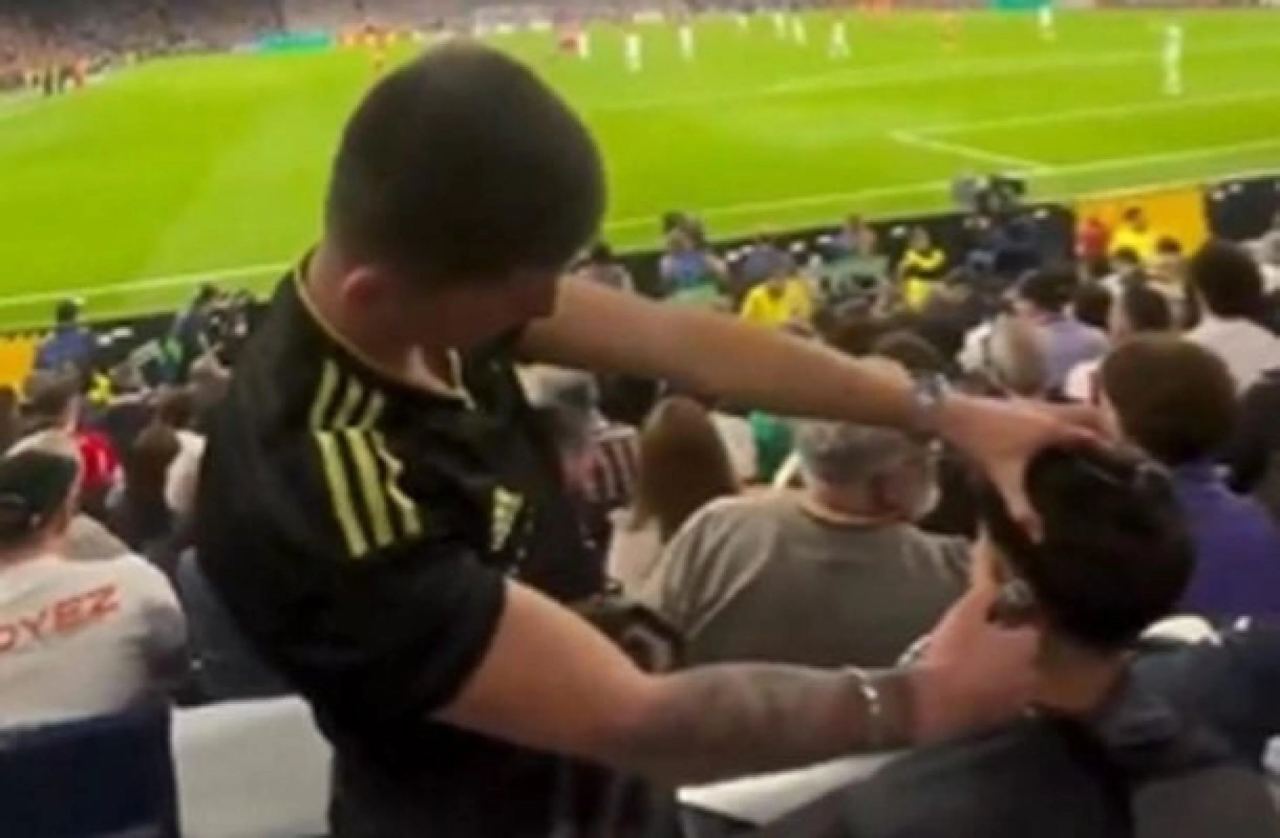 Torcedor corta cabelo na arquibancada do Santiago Bernabéu durante partida