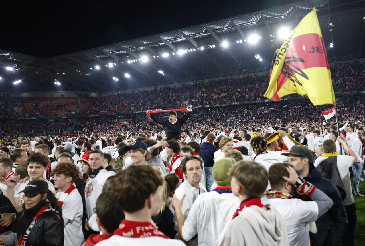 Torcedores do Freiburg no gramado comemorando classificação