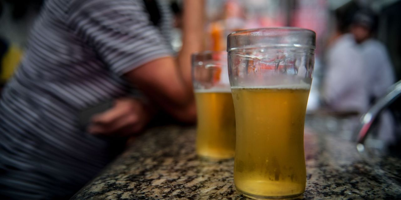 Bar com mesas vazias e aviso de proibição temporária