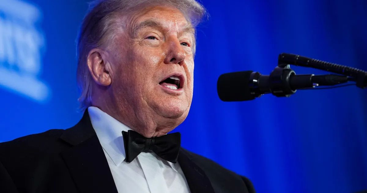 Donald Trump gesticula diante de bandeira dos EUA