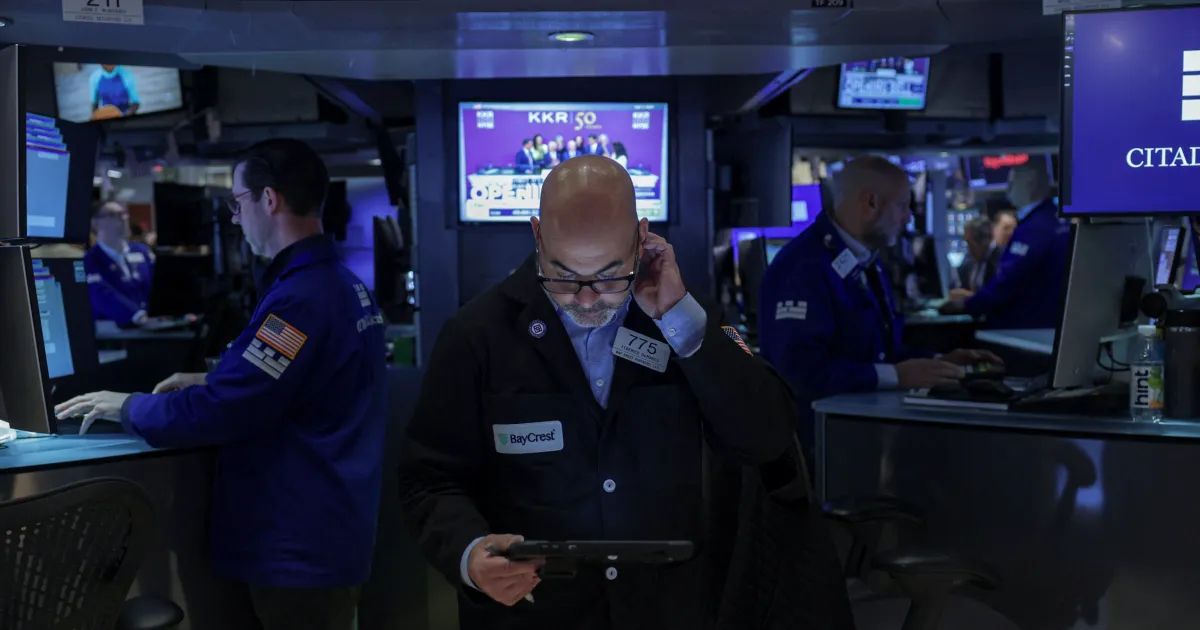 Painel com cotações da Bolsa de Nova York e bandeira dos EUA