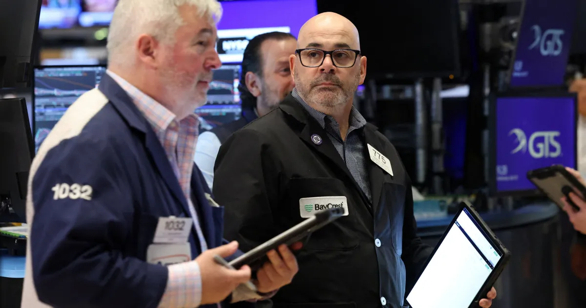 Salas de negociação em Wall Street com telas mostrando altas nos índices
