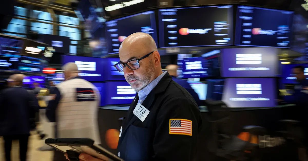 Painel com cotações do Nasdaq e S&P 500 em tela